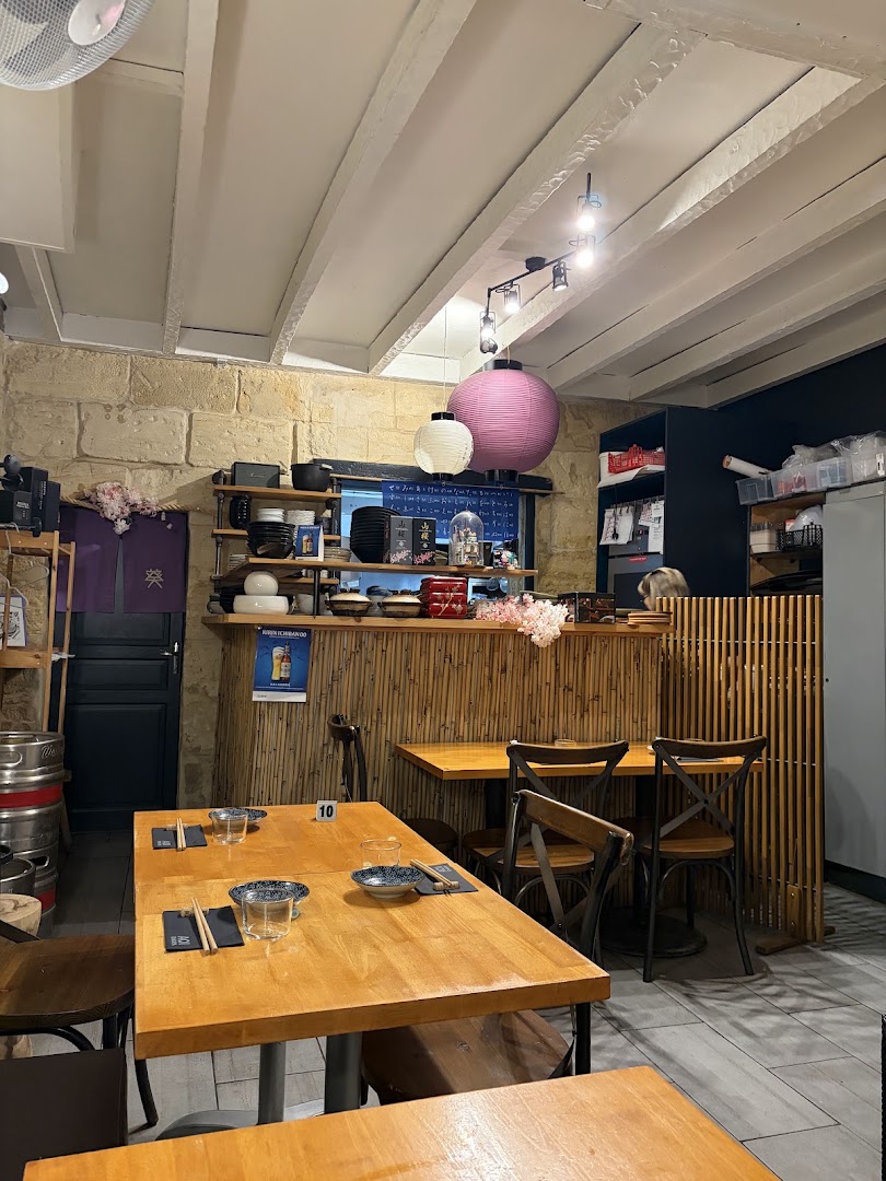 La petite salle d’AOI Izakaya avec tables en bois et comptoir
